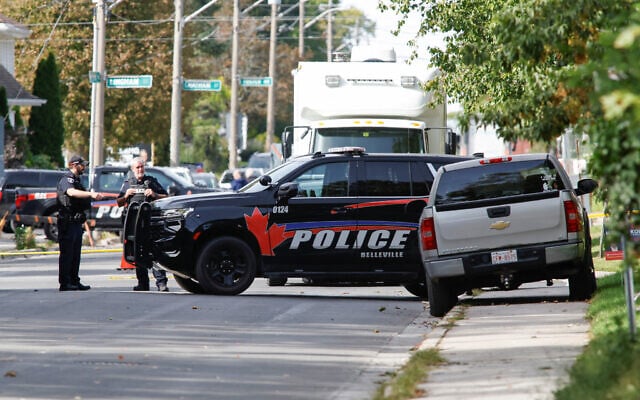 Police officers talk near the scene of a shooting where a police officer was shot outside a Yom Kippur gathering at Sons of Jacob Synagogue in Belleville, Ontario, Canada, September 21, 2026. (Patrick Doyle/Reuters)