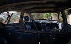 Palestinian men stand near a vehicle damaged in what they say was an Israeli settler attack, in Al-Mughayyir, near Ramallah, on September 29, 2026. (Mohamad Torokman/Reuters)