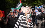 A protester with a bag on their head next to an effigy of Prime Minister Benjamin Netanyahu in a noose, in New York City, September 24, 2026. (Luke Tress/Times of Israel)
