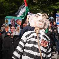 A protester with a bag on their head next to an effigy of Prime Minister Benjamin Netanyahu in a noose, in New York City, September 24, 2026. (Luke Tress/Times of Israel)