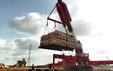 A crane moves an ancient 25-ton mikveh discovered in the southern city of Kiryat Gat, July 2026 (Emil Aladjem/Israel Antiquities Authority)