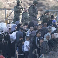 Israeli soldiers stop Palestinian farmers from Salem village at a checkpoint before entering through a closed gate onto their land to pick olives, east of Nablus in the West Bank, on November 22, 2025. (Jaafar ASHTIYEH/AFP)