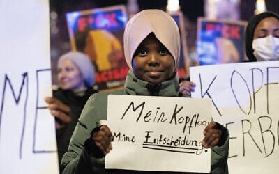 Hadiya, an 11-year old student, holds a sign that reads, in German, 'My head, my decision,' during a protest against the Austrian headscarf ban in schools, in Vienna, Austriam on February 13, 2026. (Joe Klamar/AFP)