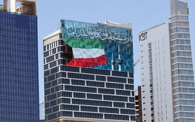 A large screen displays a verse from the Koran reading 'My Lord, make this city secure,' alongside the Kuwaiti flag and the landmark Kuwait Towers, on a skyscraper in Kuwait City on September 2, 2026. (AFP)