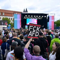 A man holds up a placard reading “FCK AFD” as he gathers with others in front of Saxony-Anhalt’s state parliament to demonstrate for an open society based on solidarity during a festival of democracy in Magdeburg, eastern Germany, on September 5, 2026, one day before regional elections in the eastern federal state of Saxony-Anhalt. (John MACDOUGALL/AFP)