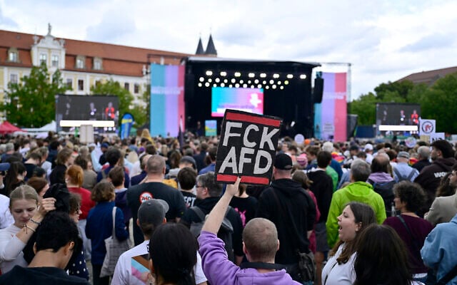 A man holds up a placard reading “FCK AFD” as he gathers with others in front of Saxony-Anhalt’s state parliament to demonstrate for an open society based on solidarity during a festival of democracy in Magdeburg, eastern Germany, on September 5, 2026, one day before regional elections in the eastern federal state of Saxony-Anhalt. (John MACDOUGALL/AFP)