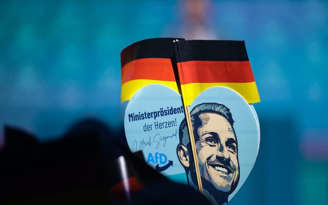 A sign held up as Ulrich Siegmund, top candidate in the Saxony-Anhalt state election for the far-right Alternative for Germany (AfD) party, addresses a campaign event in Magdeburg, eastern Germany, on September 5, 2026, one day before regional elections in the eastern federal state of Saxony-Anhalt. (Ronny HARTMANN/AFP)