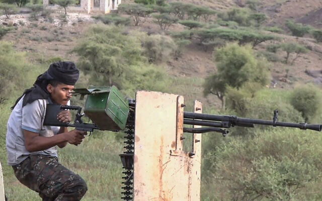 This frame grab taken from AFPTV video footage on September 9, 2026, shows a member of the Saudi-backed Yemeni government forces firing a heavy machine gun during clashes with Houthi fighters in the Al-Kadha area, west of Taiz province, on September 8, 2026. (AFPTV/AFP)