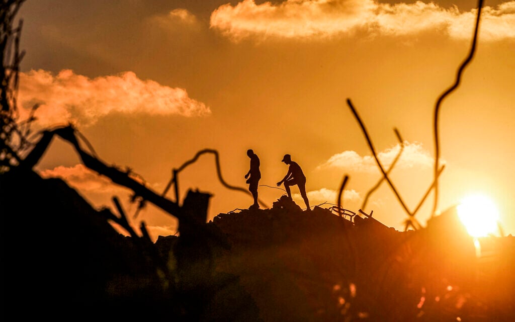Men walk through rubble at the Bureij camp in the central Gaza Strip on September 14, 2026. (EYAD BABA/AFP) Men walk through rubble at the Bureij camp in the central Gaza Strip on September 14, 2026. (EYAD BABA/AFP)