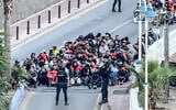 This screen grab made from UGC footage taken and released on September 18, 2026 shows hundreds of migrants from the beaches of Ceuta being rounded up by police before they were moved to a temporary camp in the Spanish enclave’s port area, weeks after a record influx overwhelmed the tiny territory. (UGC/UGC/AFP)