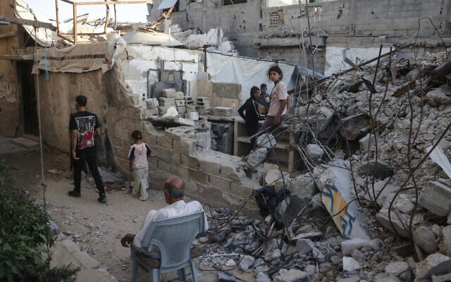 Displaced Palestinians gather amid the rubble of a heavily damaged building being used as a shelter in Khan Younis in the southern Gaza Strip on September 19, 2026. (Bashar Taleb/AFP)