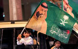 A child waves a flag bearing the image of Saudi Arabia’s Crown Price Mohammed bin Salman from a vehicle during the 96th Saudi National day celebrations in Riyadh on September 23, 2026. (Fayez NURELDINE/AFP)