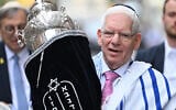 The President of the Central Council of Jews in Germany, Josef Schuster, carries the Torah scroll during the inauguration ceremony of the rooms of the first military rabbinate of the German Armed Forces Bundeswehr in Berlin, Germany, on July 4, 2024. (RALF HIRSCHBERGER/AFP/File)