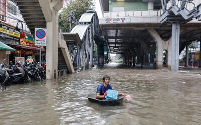 A man uses a large plastic tube to wade through floodwaters in the Bang Bua district of Bangkok on September 26, 2026. (WIKUS DE WET/AFP) A man uses a large plastic tube to wade through floodwaters in the Bang Bua district of Bangkok on September 26, 2026. (WIKUS DE WET/AFP)