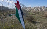 Illustrative: A placard in the shape of Israel with the colors of the Palestinian flag, and Arabic that reads 'Jerusalem is the eternal capital of Palestine,' at a barbed wire surrounding the Israeli security barrier, with the Israeli settlement of Mod’in Ilit in the background, during a protest against Israel and the US in the West Bank village of Bil’in, near Ramallah, January 31, 2020. (AP Photo/Nasser Nasser)
