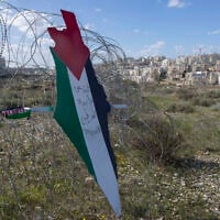 Illustrative: A placard in the shape of Israel with the colors of the Palestinian flag, and Arabic that reads 'Jerusalem is the eternal capital of Palestine,' at a barbed wire surrounding the Israeli security barrier, with the Israeli settlement of Mod’in Ilit in the background, during a protest against Israel and the US in the West Bank village of Bil’in, near Ramallah, January 31, 2020. (AP Photo/Nasser Nasser)