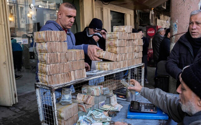 A man exchanges US dollars for stacks of Iraqi dinar in the main Shurja market in central Baghdad, Iraq, January 14, 2023. (AP Photo/Hadi Mizban) A man exchanges US dollars for stacks of Iraqi dinar in the main Shurja market in central Baghdad, Iraq, January 14, 2023. (AP Photo/Hadi Mizban)
