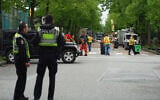Vancouver Police watch as city workers begin to clear the scene where a driver killed multiple people during a Filipino community festival April 29, 2025, in Vancouver, British Columbia. (AP Photo/Lindsey Wasson)