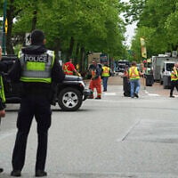 Vancouver Police watch as city workers begin to clear the scene where a driver killed multiple people during a Filipino community festival April 29, 2025, in Vancouver, British Columbia. (AP Photo/Lindsey Wasson)