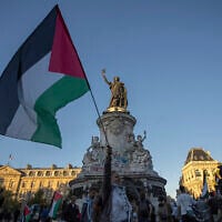 A woman holds a Palestinian flag during a demonstration at Republic Square in Paris, September 17, 2025. (AP Photo/Aurelien Morissard)