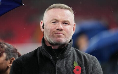 Former star striker Wayne Rooney stands on the pitch before the Champions League soccer match between Liverpool and Real Madrid in Liverpool, England, November 4, 2025. (AP Photo/Jon Super)