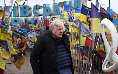 In this February 26, 2026, photo provided by Ukraine’s 65th Mechanized Brigade press service, Britain’s former Prime Minister Boris Johnson stands at the city entrance sign surrounded by Ukrainian national flags and flags of military units as he visits the frontline town of Orikhiv in the Zaporizhzhia region, Ukraine. (Andriy Andriyenko/Ukraine’s 65th Mechanized Brigade via AP)