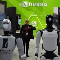 A worker stands near robots at the Nvidia booth during the China International Supply Chain Expo in Beijing on June 22, 2026. (Ng Han Guan/AP)
