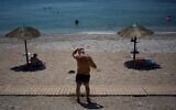 A man cools himself with water on Flisvos Beach during a heat wave in Athens, Greece, August 24, 2026. (AP Photo/Thanassis Stavrakis)