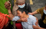 Relatives console Muna Khadka, center, who lost her son Aayush Khada in flash floods, at a cremation ground in Chitwan, Nepal, August 31, 2026.