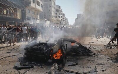 Illustrative: Palestinians gather around the burning wreckage of a car after an Israeli army strike in Gaza City, August 31, 2026. (AP Photo/Yousef Alzanoun) Illustrative: Palestinians gather around the burning wreckage of a car after an Israeli army strike in Gaza City, August 31, 2026. (AP Photo/Yousef Alzanoun)
