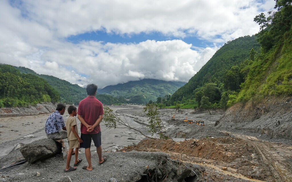 People watch as earthmovers clear debris along the swollen Trishuli River in the aftermath of flash flooding at 1 Number Pul, in Nepal’s Nuwakot district, September 1, 2026. (AP Photo/Rajesh Kumar Singh) People watch as earthmovers clear debris along the swollen Trishuli River in the aftermath of flash flooding at 1 Number Pul, in Nepal’s Nuwakot district, September 1, 2026. (AP Photo/Rajesh Kumar Singh)