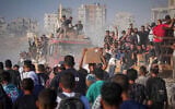 Palestinians ride on a truck loaded with food and humanitarian aid from the World Food Program, after it arrived in the northern Gaza Strip, June 16, 2025. (Jehad Alshrafi/AP)