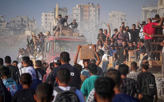 Palestinians ride on a truck loaded with food and humanitarian aid from the World Food Program, after it arrived in the northern Gaza Strip, June 16, 2025. (Jehad Alshrafi/AP)