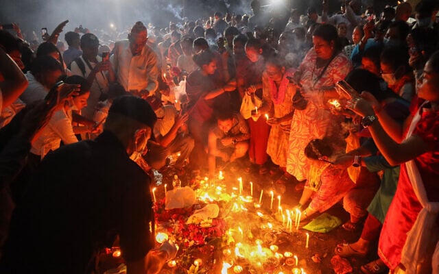 People gather to light candles and pray for the victims of flash floods at the site of a mass burial in Chitwan, Nepal, September 1, 2026. (AP Photo/Nisha Shrestha)