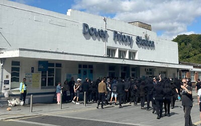 Protesters gather at Dover Priory train station after black-clad and masked demonstrators blocked roads during a protest, in Dover, England, September 5, 2026. (Oscar Rihll/PA via AP)