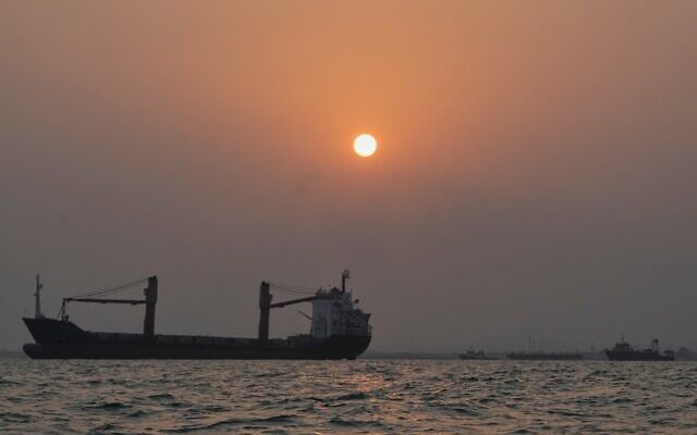 The sun sets over commercial vessels anchored in the Strait of Hormuz off Bandar Abbas, Iran, with the city’s skyline in the background, September 6, 2026. (AP Photo/Vahid Salemi)