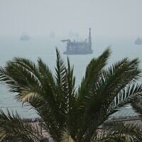 A floating dredging platform and commercial vessels lie anchored amid haze in the Strait of Hormuz off Bandar Abbas, Iran, September 7, 2026. (AP Photo/Vahid Salemi)