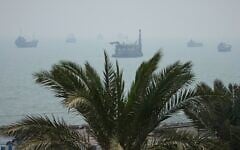 A floating dredging platform and commercial vessels lie anchored amid haze in the Strait of Hormuz off Bandar Abbas, Iran, September 7, 2026. (AP Photo/Vahid Salemi)