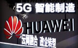 Signs promoting 5G wireless technology from Chinese technology firm Huawei are displayed at the PT Expo in Beijing on September 26, 2018. (AP Photo/Mark Schiefelbein)