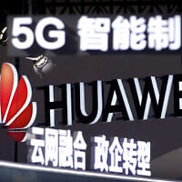 Signs promoting 5G wireless technology from Chinese technology firm Huawei are displayed at the PT Expo in Beijing on September 26, 2018. (AP Photo/Mark Schiefelbein)