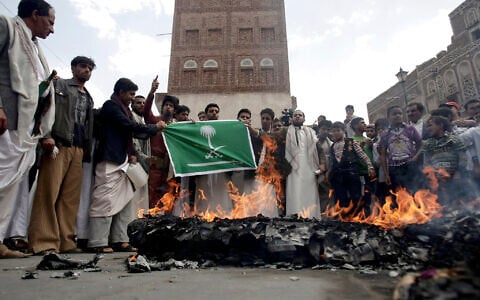 Members of the Iran-backed Houthi rebel group burn an effigy of a US aircraft and a Saudi flag during a demonstration against US and Saudi interference in Yemen, after Friday prayers in Sanaa, Yemen, on April 12, 2013.