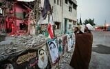 A cleric takes a photograph at the shattered Shajareh Tayyebeh school, which has become a place of mourning and a memorial to those killed in a US airstrike on February 28, in Minab, southern Iran, September 7, 2026. (AP Photo/Vahid Salemi)
