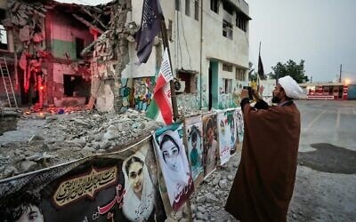A cleric takes a photograph at the shattered Shajareh Tayyebeh school, which has become a place of mourning and a memorial to those killed in a US airstrike on February 28, in Minab, southern Iran, September 7, 2026. (AP Photo/Vahid Salemi) A cleric takes a photograph at the shattered Shajareh Tayyebeh school, which has become a place of mourning and a memorial to those killed in a US airstrike on February 28, in Minab, southern Iran, September 7, 2026. (AP Photo/Vahid Salemi)