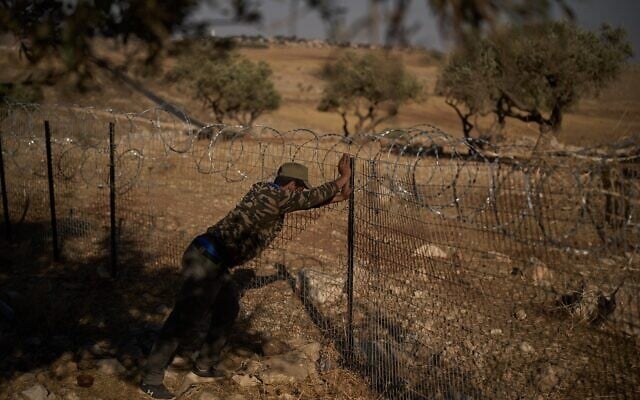 A man works on a fence at a Palestinian-Bedouin family’s house to try to prevent attacks from Israeli settlers on the outskirts of the West Bank town of Taybeh, September 9, 2026. (AP Photo/Leo Correa)