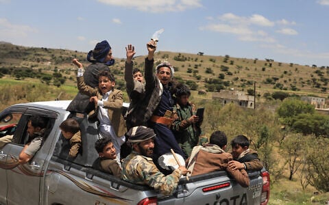 Yemeni civilians celebrate while riding in the back of a pickup truck in the Bani Matar district, Yemen, September 12, 2026, as they follow a convoy carrying Houthi prisoners freed in Mocha on its way to Sanaa following the Houthi takeover of the southern Red Sea port city. (AP Photo/STR)