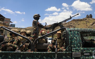 Houthi fighters escort a convoy carrying prisoners freed in Mokha through the Bani Matar district on its way to Sanaa, Yemen, September 12, 2026, following the Houthi takeover of the southern Red Sea port city. (AP Photo/STR)