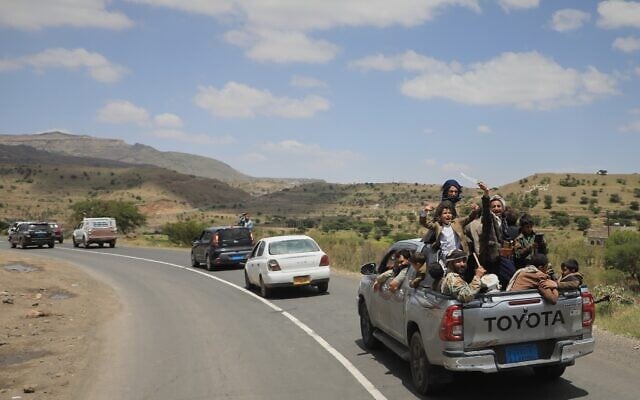 Yemeni civilians celebrate while riding in the back of a pickup truck in the Bani Matar district, Yemen, September 12, 2026, as they follow a convoy carrying Houthi prisoners freed in Mokha on its way to Sanaa following the Houthi takeover of the southern Red Sea port city. (AP Photo/STR)