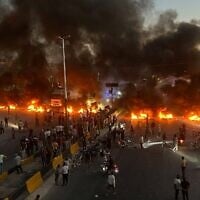 Protesters burn tires and other debris to block a highway as demonstrations over fuel price increases spread across Syria, in Maarat al-Numan, Idlib province, September 13, 2026. (AP Photo/Ahmed Albam)