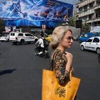 Pedestrian walk past a billboard depicting a Persian legendary hero and flying figure hitting US aircraft carriers alongside the message in English and Farsi: “From the Persian Gulf a new power rises” “The army of Satan will be drowned in the Persian Gulf, “ at Islamic Revolution square in downtown Tehran, Iran, September 14, 2026. (AP Photo/Vahid Salemi)