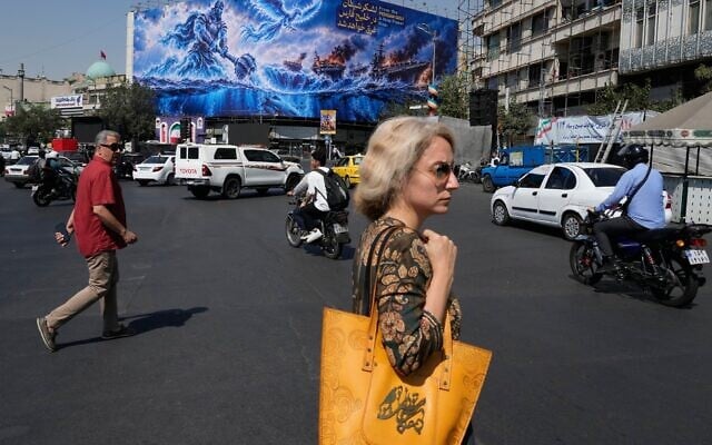Pedestrian walk past a billboard depicting a Persian legendary hero and flying figure hitting US aircraft carriers alongside the message in English and Farsi: “From the Persian Gulf a new power rises” “The army of Satan will be drowned in the Persian Gulf, “ at Islamic Revolution square in downtown Tehran, Iran, September 14, 2026. (AP Photo/Vahid Salemi) Pedestrian walk past a billboard depicting a Persian legendary hero and flying figure hitting US aircraft carriers alongside the message in English and Farsi: “From the Persian Gulf a new power rises” “The army of Satan will be drowned in the Persian Gulf, “ at Islamic Revolution square in downtown Tehran, Iran, September 14, 2026. (AP Photo/Vahid Salemi)